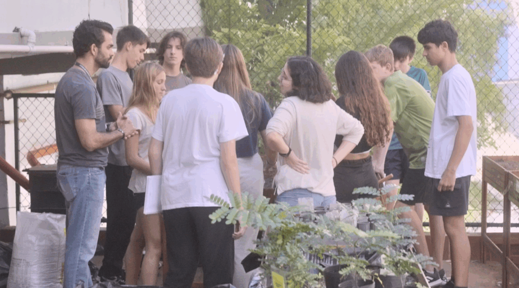 Alunos e alunas do Colégio São Vicente de Paulo participam de uma atividade prática na horta escolar, orientados pelo professor. A experiência faz parte da Oficina de Sustentabilidade.